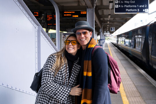 Couple hugging at train station platform