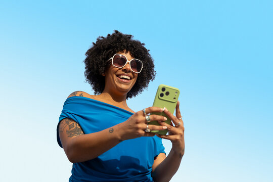 Confident  Black mobile phone outdoors blue sky texting 