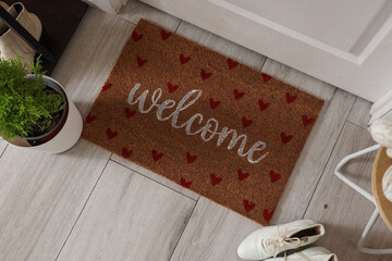 Obraz premium Doormat with winter shoes and Cypress tree in hallway, top view