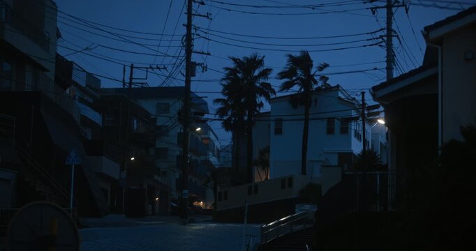 Narrow Residential Street With Harsh Wind Blowing Trees at Dusk In Japanese Town