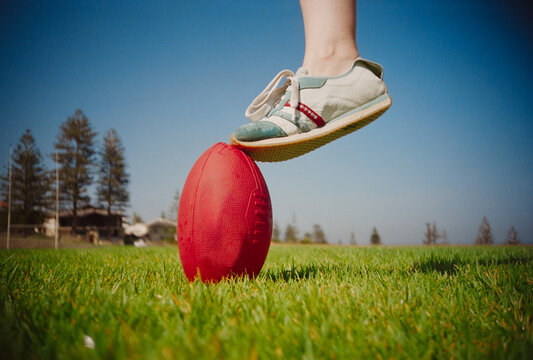 Kick of an AFL Ball on a Sunny Day at the Park