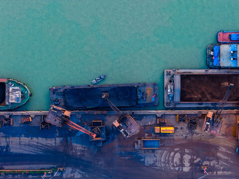 Aerial view of industrial port with cargo ships and factory complex