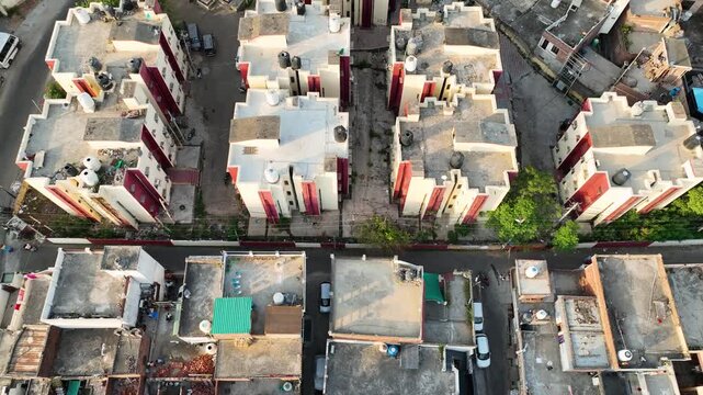 Drone flies forward looking down at urban housing infrastructure.