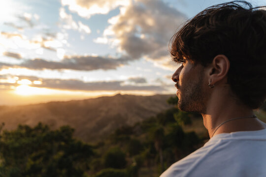 Man contemplating sunset with mountain view and peaceful thoughts