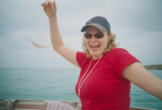 Woman Enjoying Fishing on a Small Boat in the Ocean
