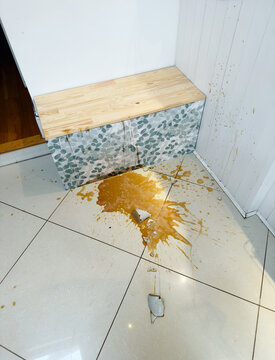 Coffee Spills on Floor Near Cabinet in a Home Kitchen