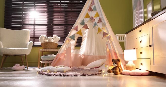 Beautiful wigwam, cushions and toys in child's room. Camera moving left