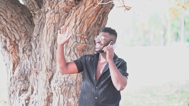 Smiling Man Greeting While Talking on Smartphone