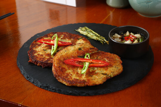 Close up of traditional Korean mung bean pancakes (bindaetteok) on a black slate plate 검은색 스톤 플레이트 위에 올려진 전통 한국식 녹두전 클로즈업