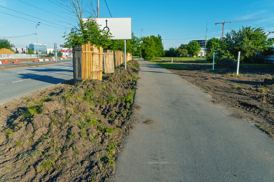 Suburban sidewalk beside road with new landscaping and construction