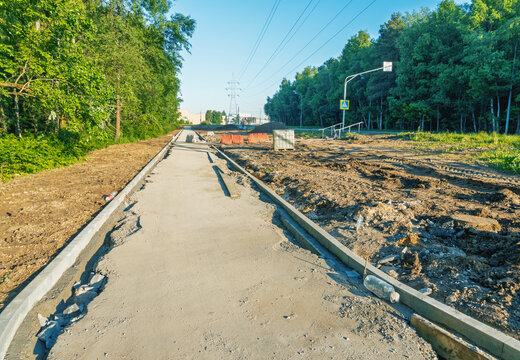 Construction of a concrete sidewalk beside a forest road