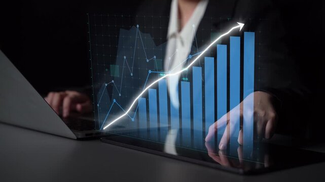 A business professional interacts with a laptop displaying a holographic graph, highlighting financial growth and strategic insights in a digital workspace setting. Copula