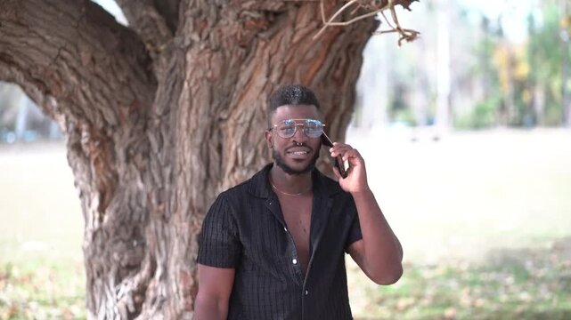 Man Using Smartphone and Greeting Someone in Park