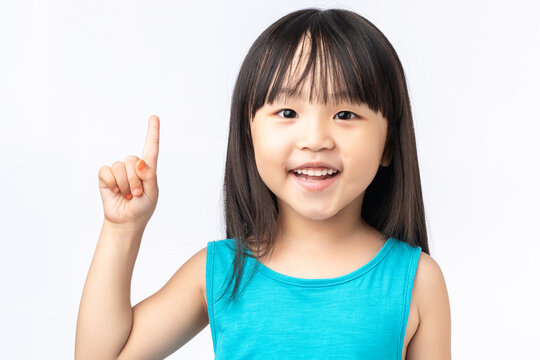 Happy Asian girl pointing finger up having a great idea, eureka moment or discovery concept.