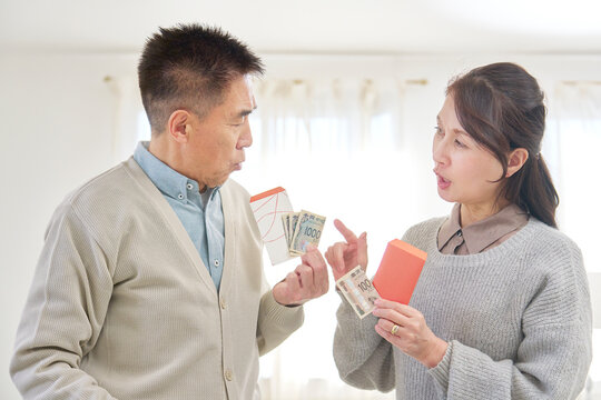 ポチ袋を持ってお年玉の金額の相談をするシニア男性と女性