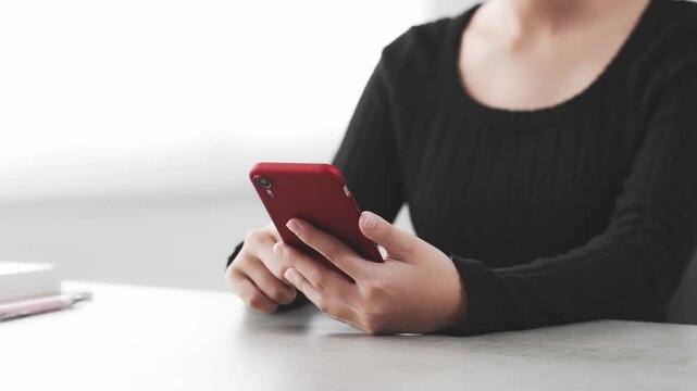 A woman using her smartphone in her room