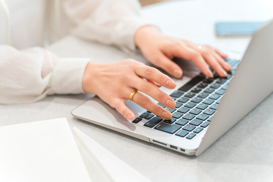 A woman's hands while using a laptop (typing, teleworking, side job, part-time work)