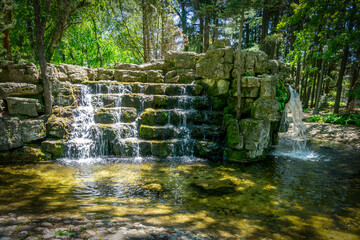 Scenic waterfalls and cascades within Confederation Park in Stratford, Ontario, creating a tranquil natural feature surrounded by lush greenery and historic park landscaping. © Mehdi