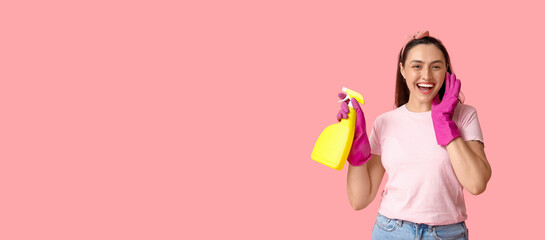 Obraz premium Beautiful young happy woman in gloves with bottle of detergent on pink background