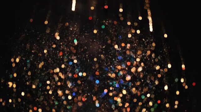 Fireworks explode in bright light creating bokeh effect on a black background during night celebrations