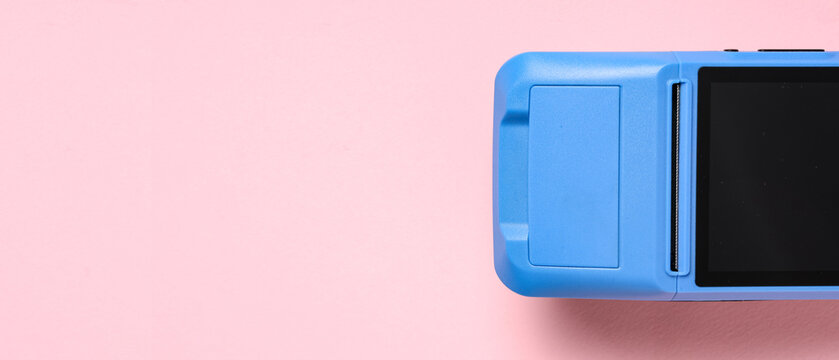 Payment terminal on pink background, top view