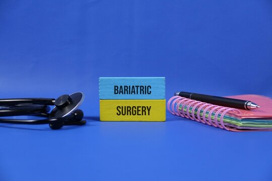 Bariatric Surgery Concept With Stethoscope Notebook And Pen On dark blue Background For Weight Loss.