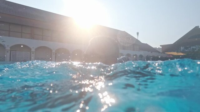 Athletic sportsman swimming in outdoors pool during fitness training. 