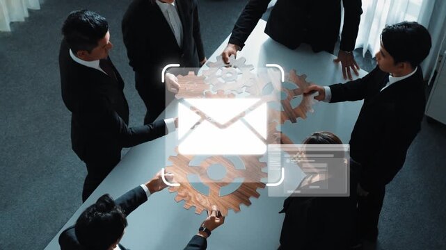 A group of professionals engages in teamwork around a table, symbolizing collaboration, communication, and workflow enhancement with digital mail concepts. Raster
