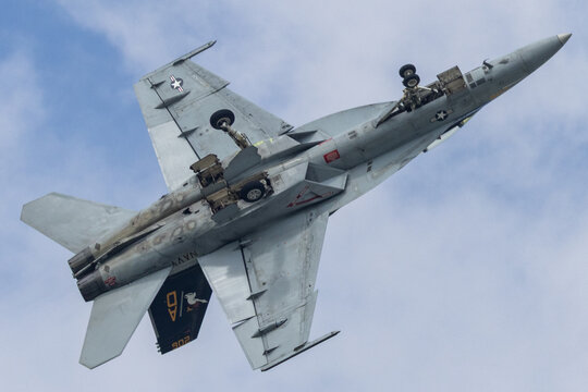 F/A-18 Hornet fighter jet banking overhead
