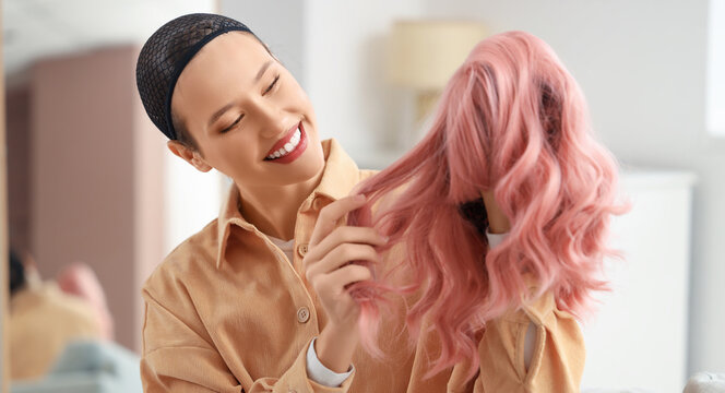 Beautiful young woman with pink wig at home