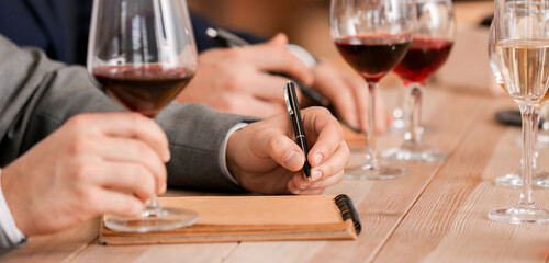 Fototapeta premium People tasting wine at the restaurant, closeup