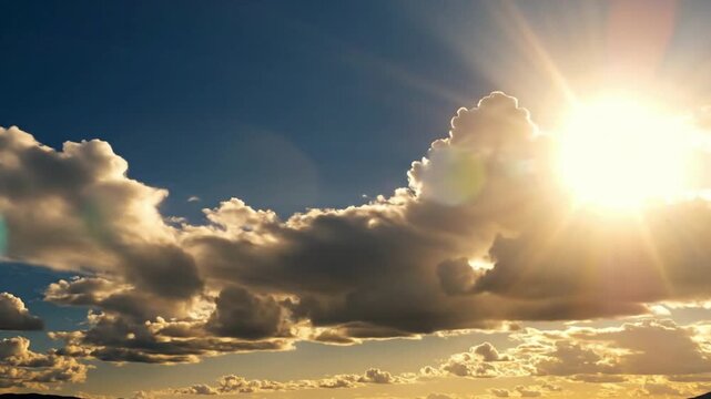 Clouds move under the afternoon sun in clear skies with light shining through from above