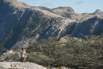 Fototapeta premium Woman Hiking Through Patagonian Wilderness Beneath Granite Mountains