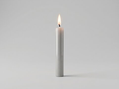 A burning white candle on a clean background