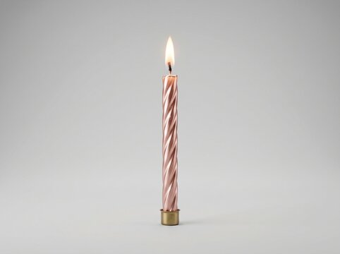 A burning metallic rose gold spiral birthday candle