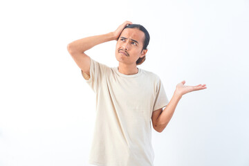 Naklejka premium Young Asian man in a shirt, with a confused face expression. Isolated on a white background