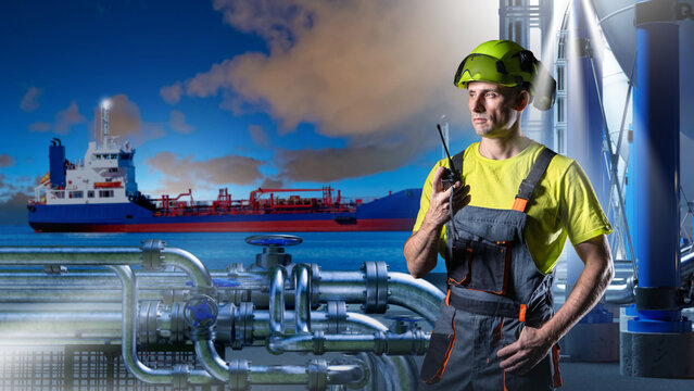 Marine fuel terminal. Industrial operator uses radio near pipelines while tanker ship supports offshore oil and gas logistics.