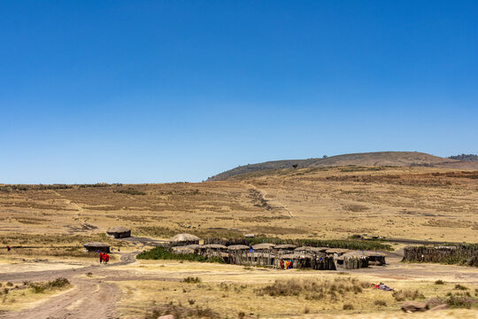 View of a traditional Maasai settlement boma under a clear blue sky in Ngorongoro Tanzania