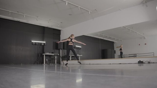 Acrobatic young female ballet dancers training in a modern dance studio