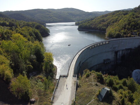 Aerial view of dam and reservoir surrounded by green forest hills in Serbia near Uzice. g.