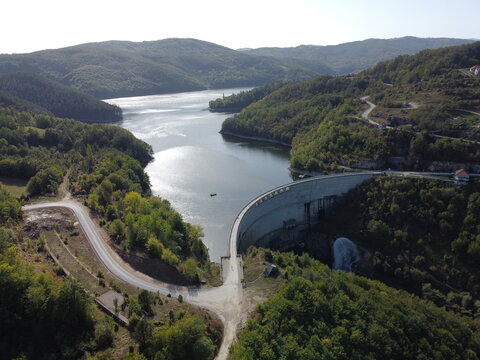 Aerial view of dam and reservoir surrounded by green forest hills in Serbia near Uzice. g.