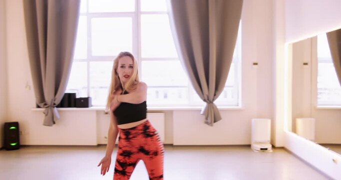 Woman dancing. Studio practice. Female sensual moving arms hips bending in light room with mirror. Active flexibility fitness show.