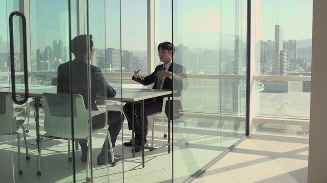 Two businessmen in a modern glass office discussing strategy with a panoramic city skyline view. Professional corporate meeting, collaboration, and executive communication.