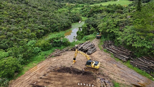 Aerial drone photo of land development with excavator and logs in tropical forest, Japan