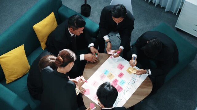 Top view of smart business team write marketing plan and putting stick notes on mind map. Group of happy business people brainstorm financial idea and planning strategy at meeting room. Directorate.