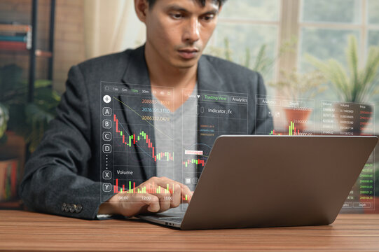 Man Analyzing Financial Charts on Laptop Displaying Stock Data