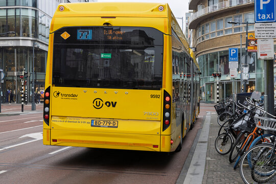 Utrecht, Netherlands. 02 April 2026. Rear view of a yellow electric Volvo public transit bus operated by Transdev U-OV on a city street near bike parking.