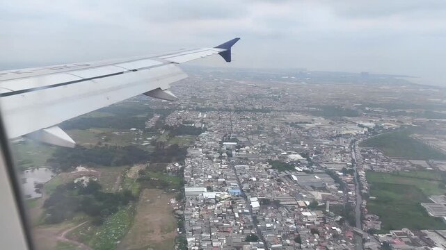 The white wing of an airplane with a distinctive purple winglet cuts through the upper left frame.