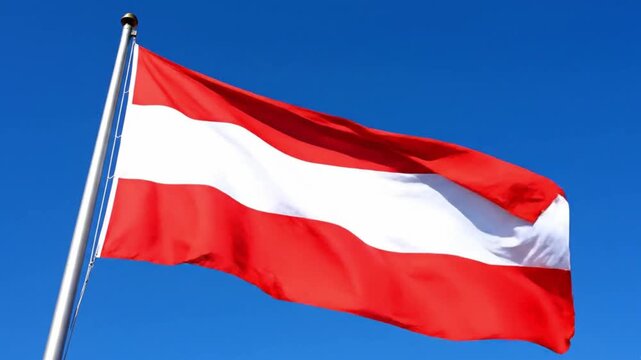 The national flag of austria waving against a clear blue sky