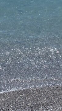 Gentle Waves Lapping on a Pebble Beach Shoreline in Italy